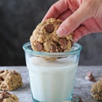 Dipping a plant-based chocolate chip cookie into a glass of milk