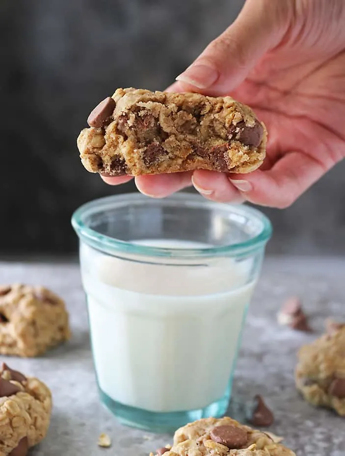 Taking a bite of an eggless oat chocolate chip cookie.