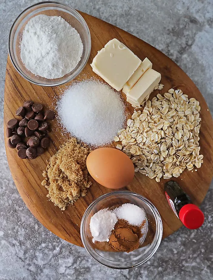 12 ingredients to make oatmeal cookies gluten-free on a cutting board.