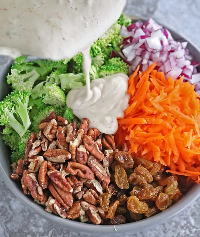 Adding cashew cream sauce to other-ingredients for broccoli salad