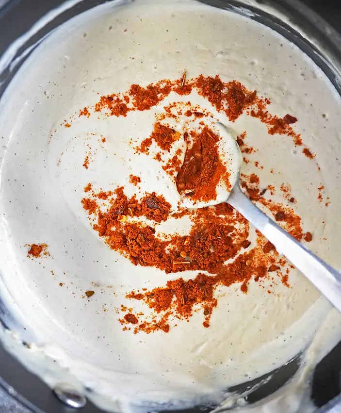 adding harissa to cashew cream with garlic lemon zest cashews almond milk maple syrup apple cider vinegar