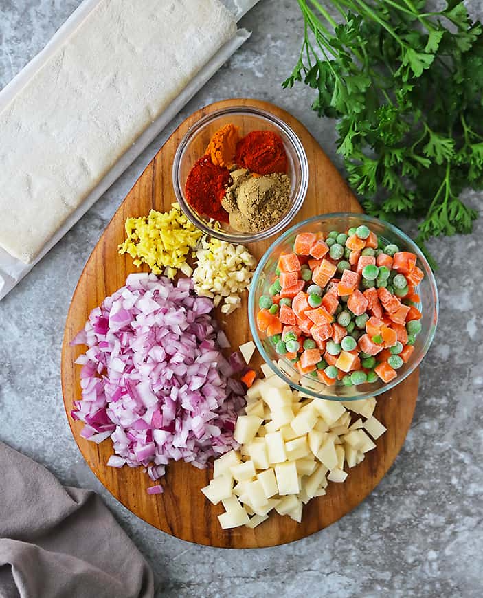 Ingredients to make easy vegetable puffs laid out on a cutting board.