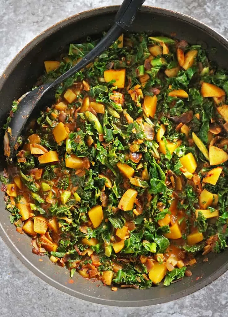 Cooking kale curry on stovetop