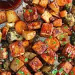 Tofu is spiced and oven roasted until crispy, along with a medley of comforting vegetables in this Easy Sheet Pan Spicy Tofu dish.