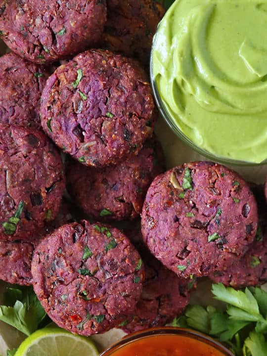 A tray with harissa spiced purple sweet potato fritters .
