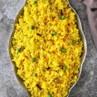 A big gray tray with Yellow rice with cardamom and cloves.