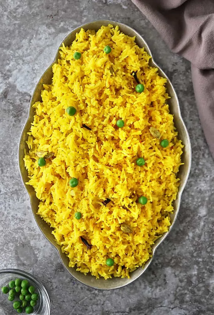 A big gray tray with Yellow rice with cardamom and cloves.