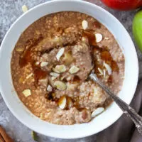 A big bowl of Delicious breakfast couscous with Cinnamon And Apples and maple syrup.