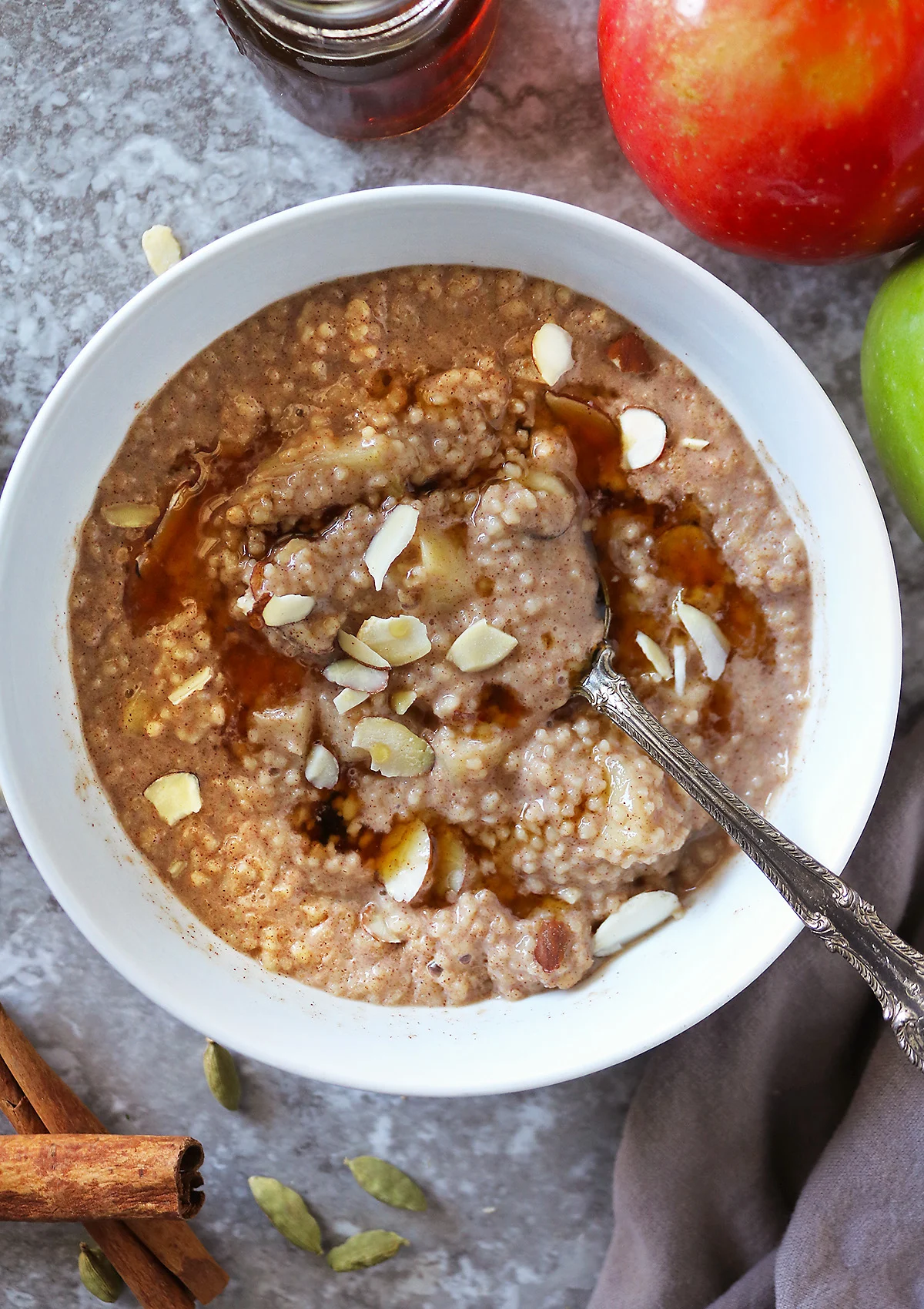 A big bowl of Delicious breakfast couscous with Cinnamon And Apples and maple syrup.