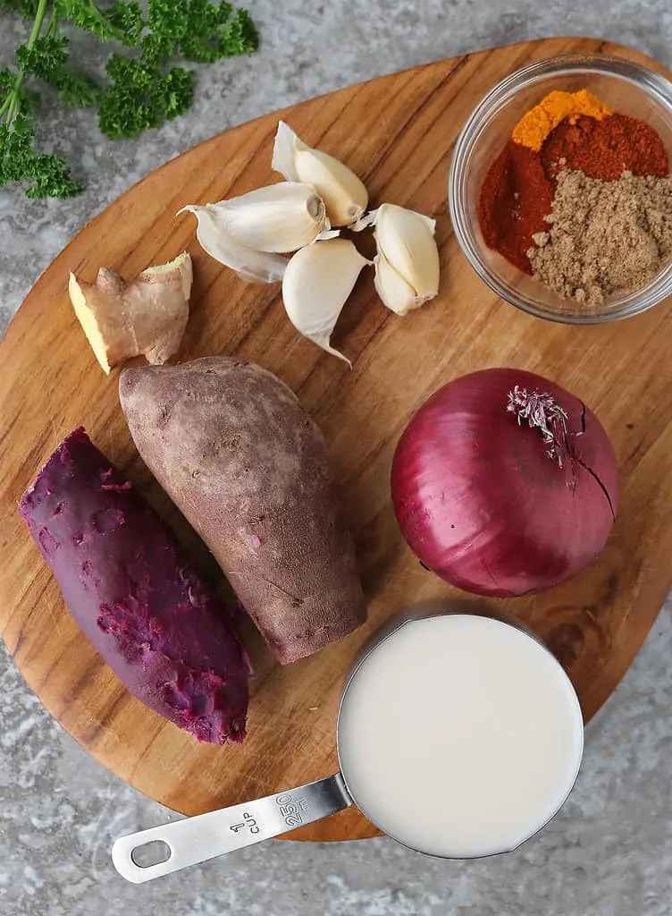 Ingredients to make purple sweet potato soup on a wood board.