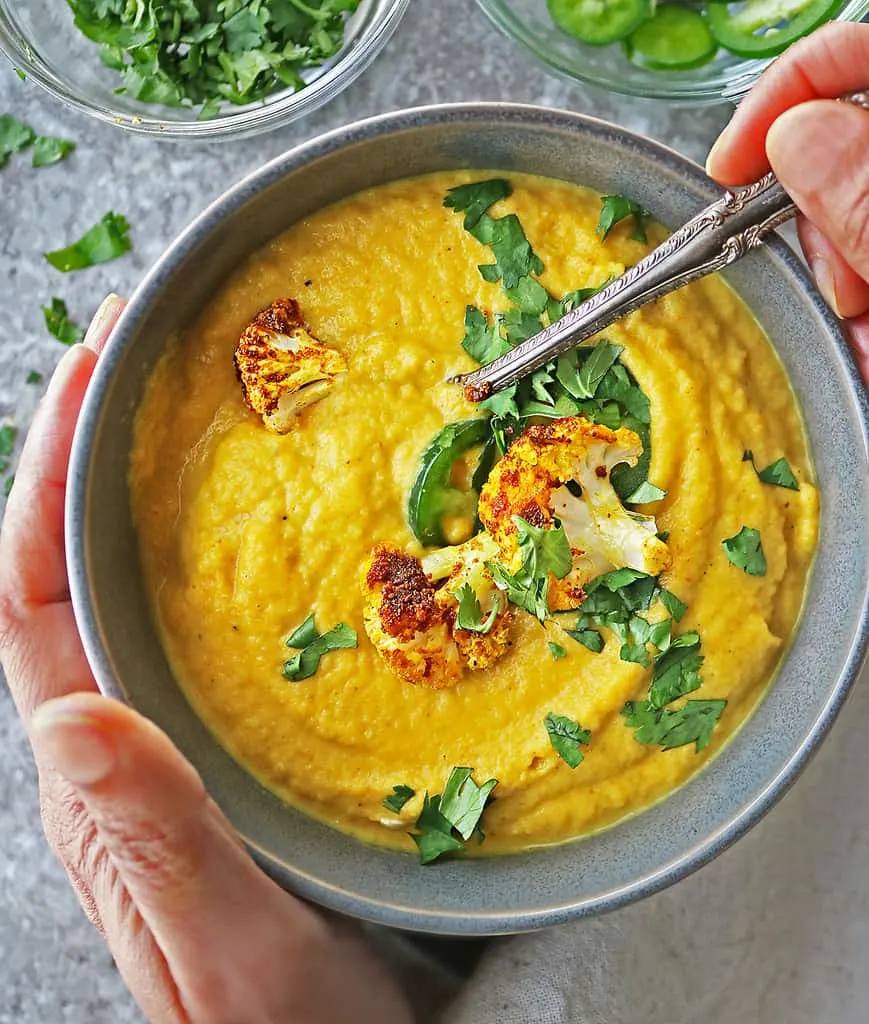 Digging into a big bowl of creamy vegan cauliflower soup.