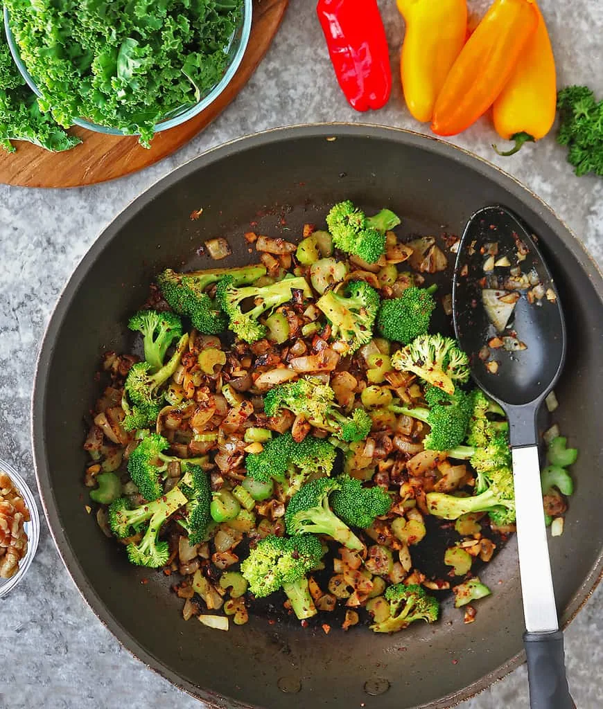 Sauteing ingredients to make warm quinoa salad