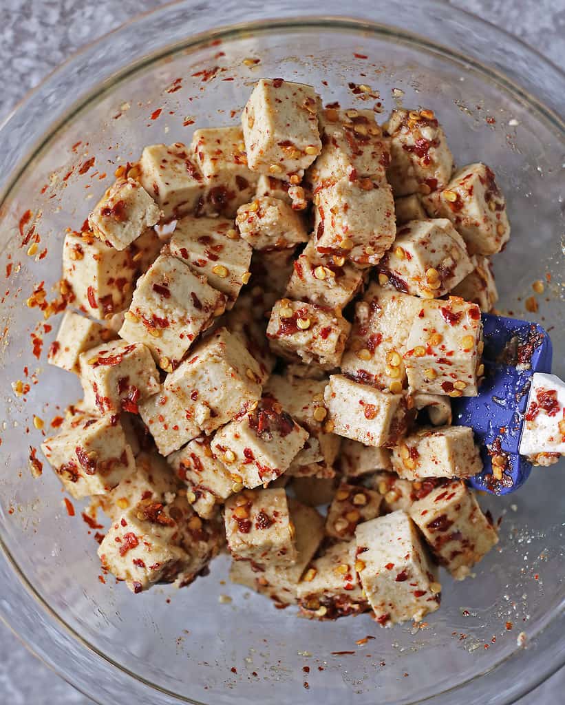 Tossing tofu with maple chili marinade