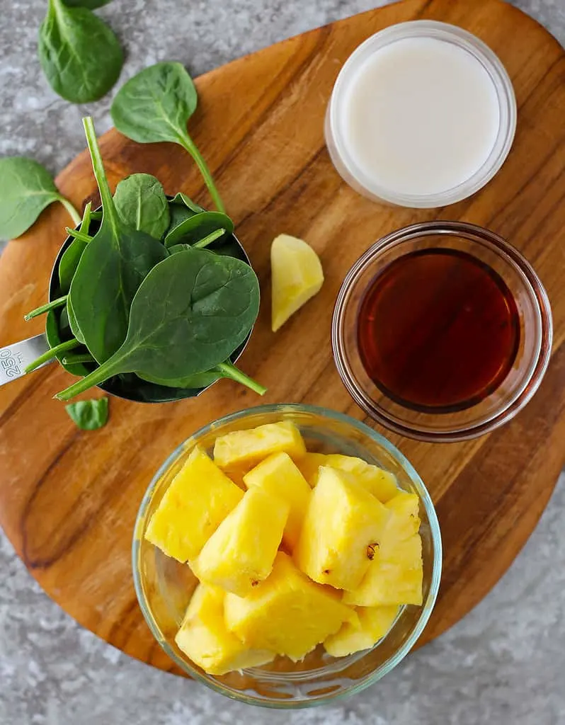 The 5 ingredients needed to make this gut-friendly green smoothie laid out on a cutting board.