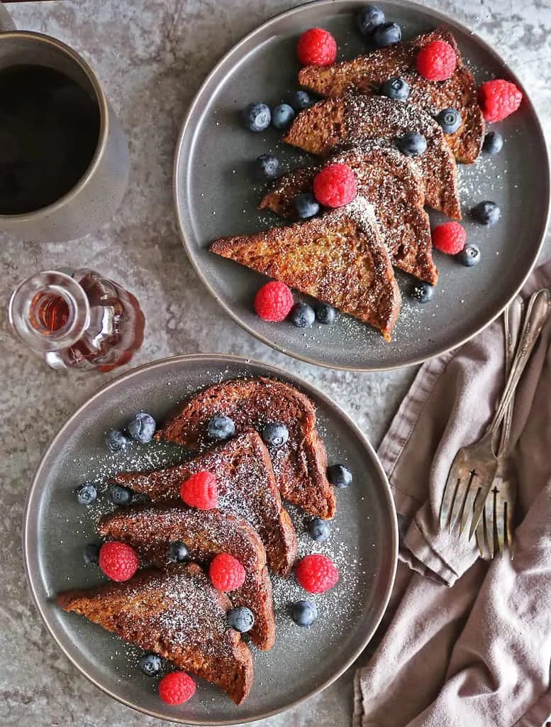The best French toast that is vegan served with fruit and powdered sugar