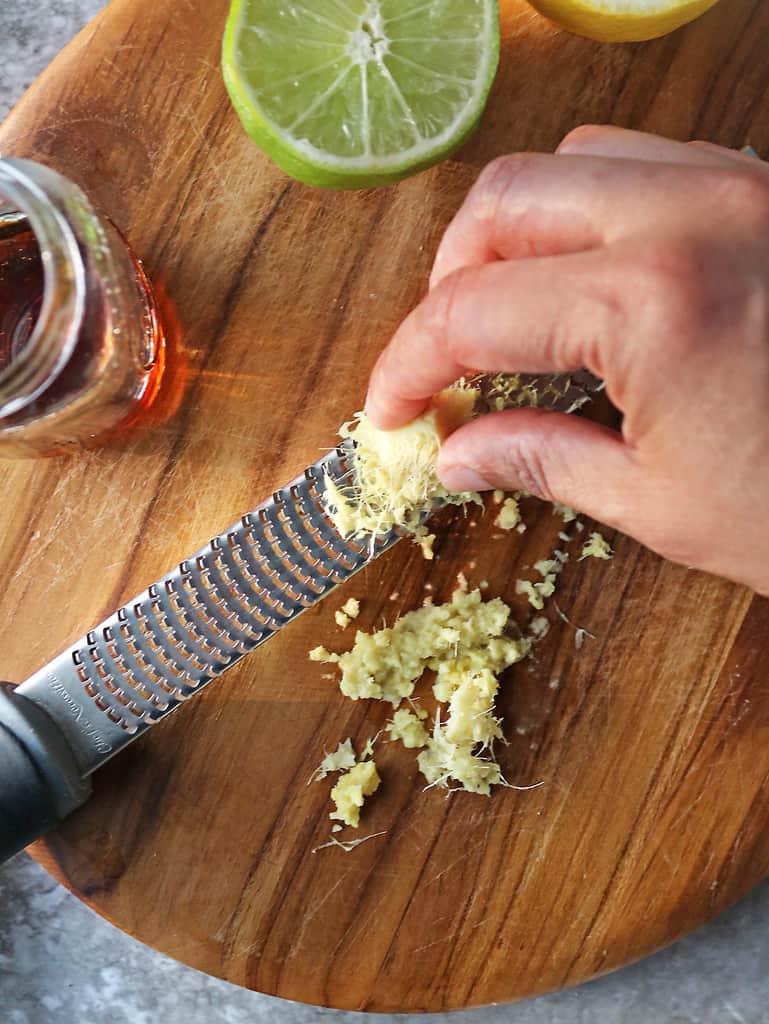 Grating fresh ginger to make a refreshing healthier drink