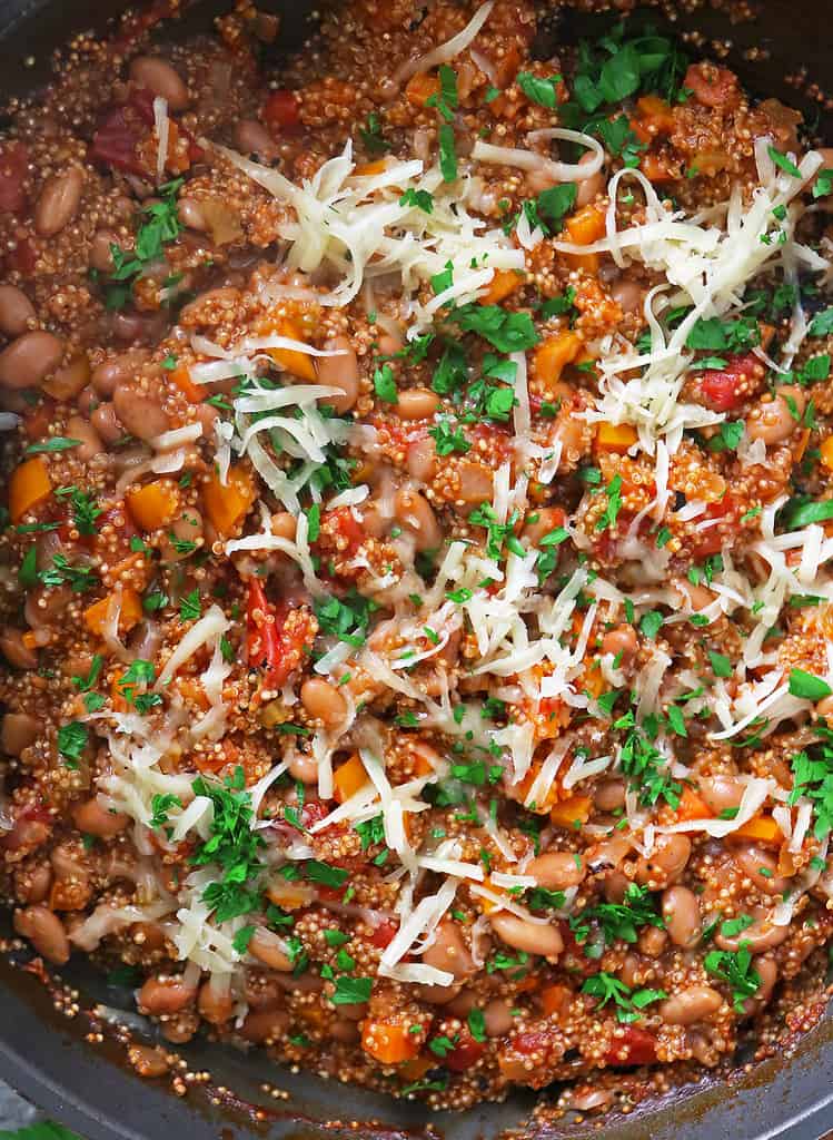 A pan of tasty enchilada quinoa with cheese and parsley.
