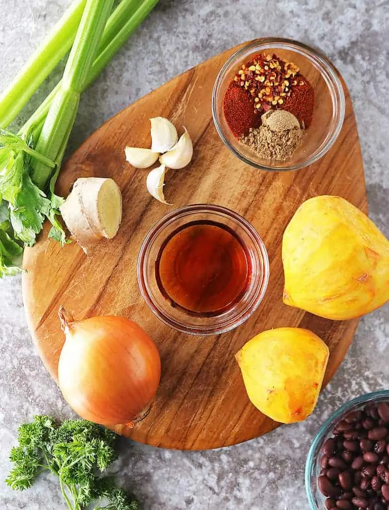The 11 Ingredients to make Black Bean Golden Beets recipe on a cutting board