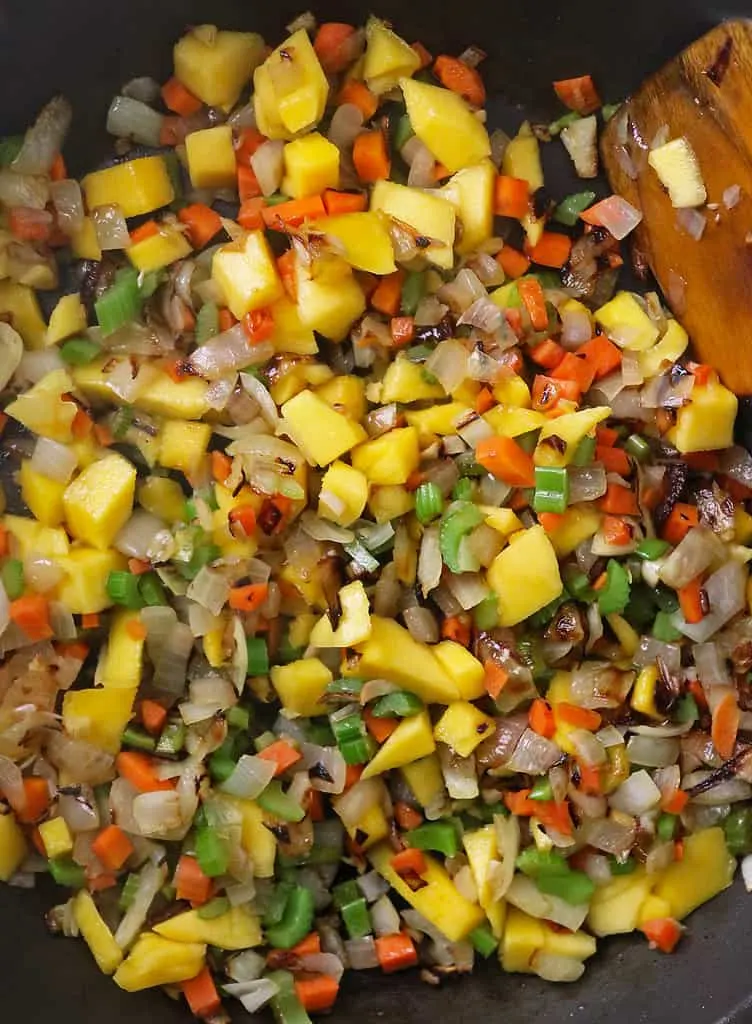 Sautéing ingredients to make quinoa with mango