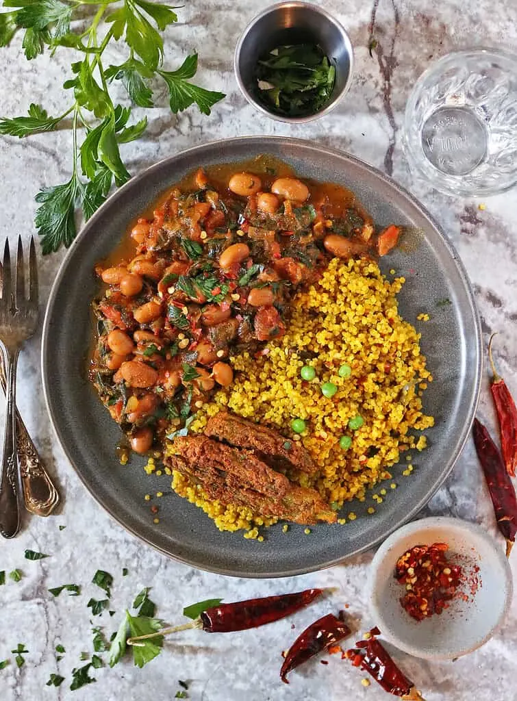 A plate with Turmeric quinoa and pinto bean curry and some air-fryer okra.