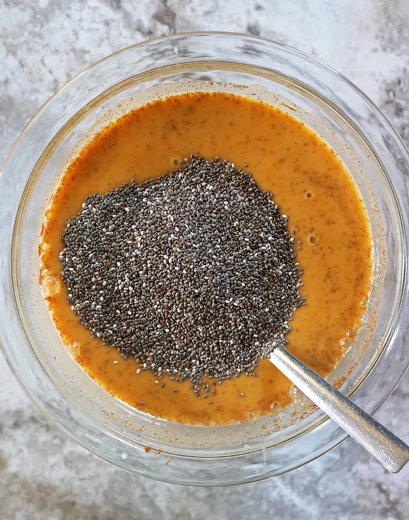 Making the best chia pudding recipe in a large glass bowl.