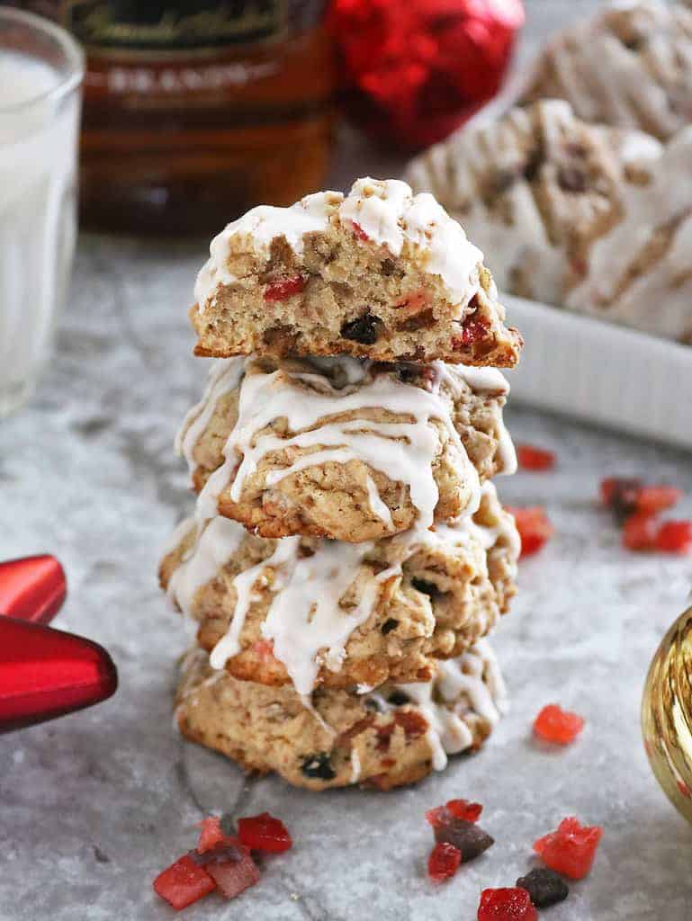 A stack of Fruitcake Cookies with Christmas ornaments in the background