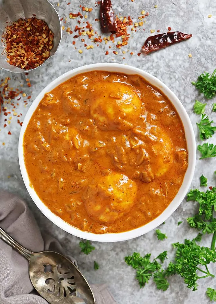 Adding eggs to tasty tomato curry sauce