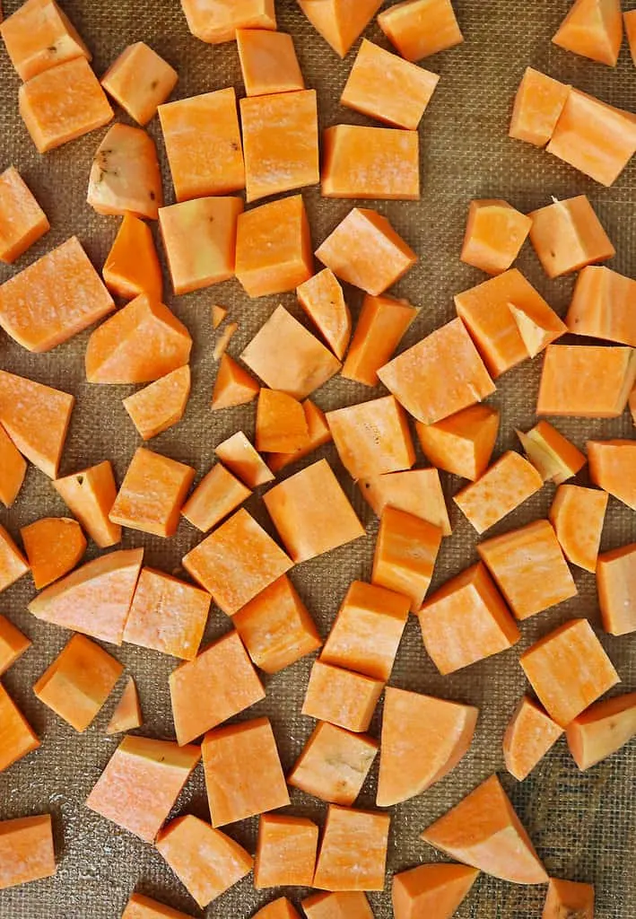 Prepping cubed sweet potatoes to roast