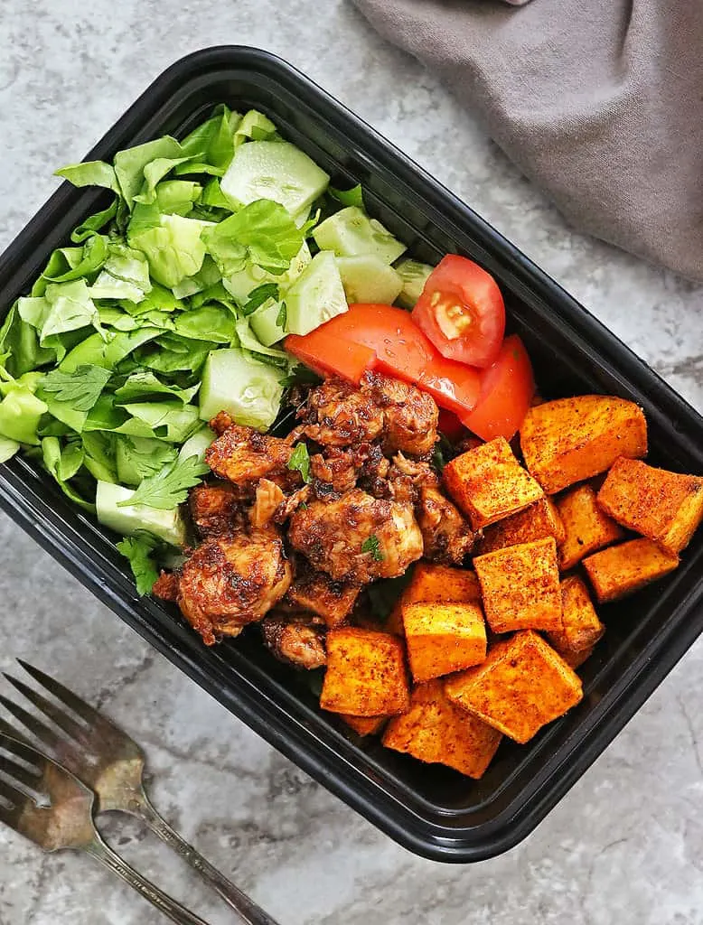 Meal prepping with the best roasted sweet potatoes along with lettuce, cucumbers, tomatoes, and cherry chicken.