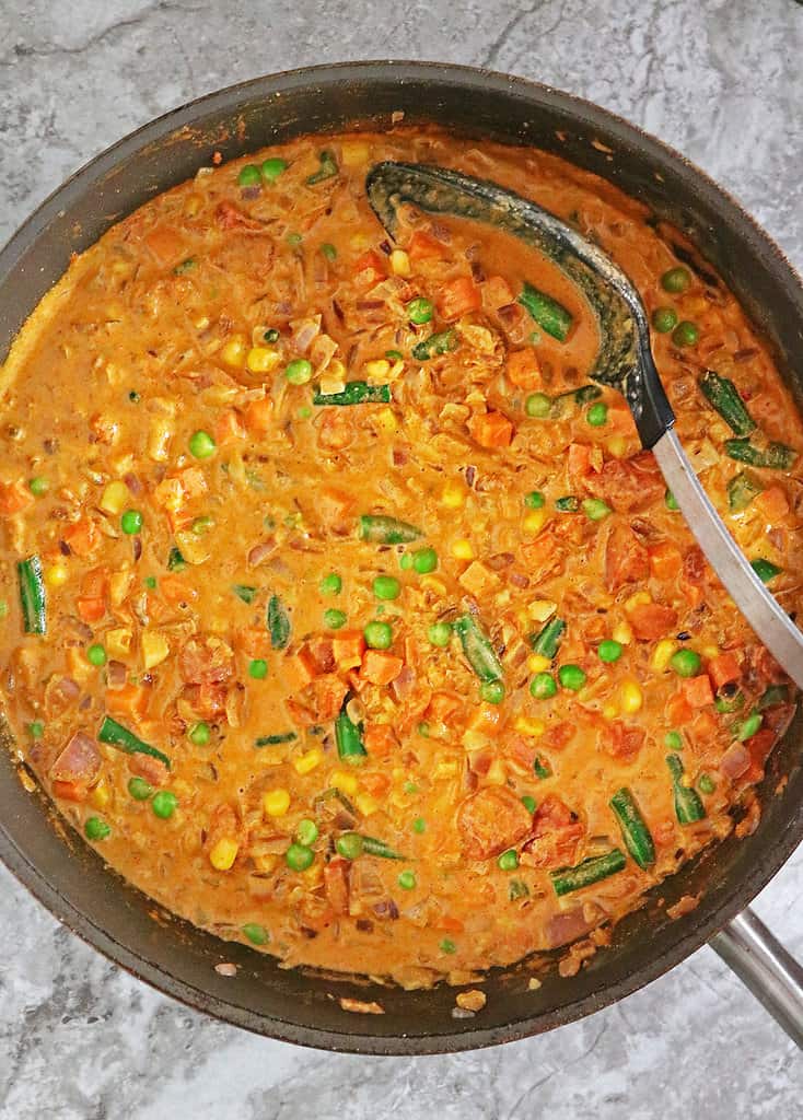 Easy creamy vegan mixed veggie curry with frozen vegetables in the pan.