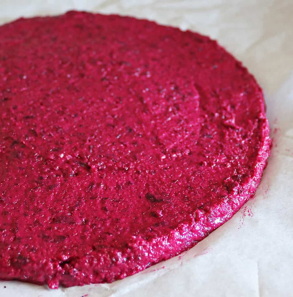 Side view of formed beet crust pizza ready to bake.