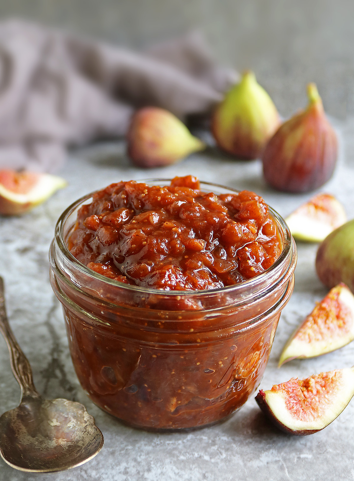 Easy Tasty Fig Chutney in a jar with a spoon near it.