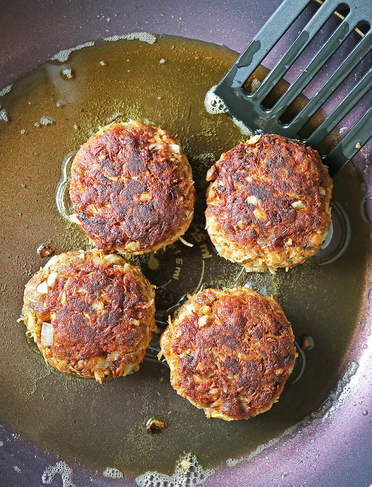 Flipped chicken patties cooked to golden brown.