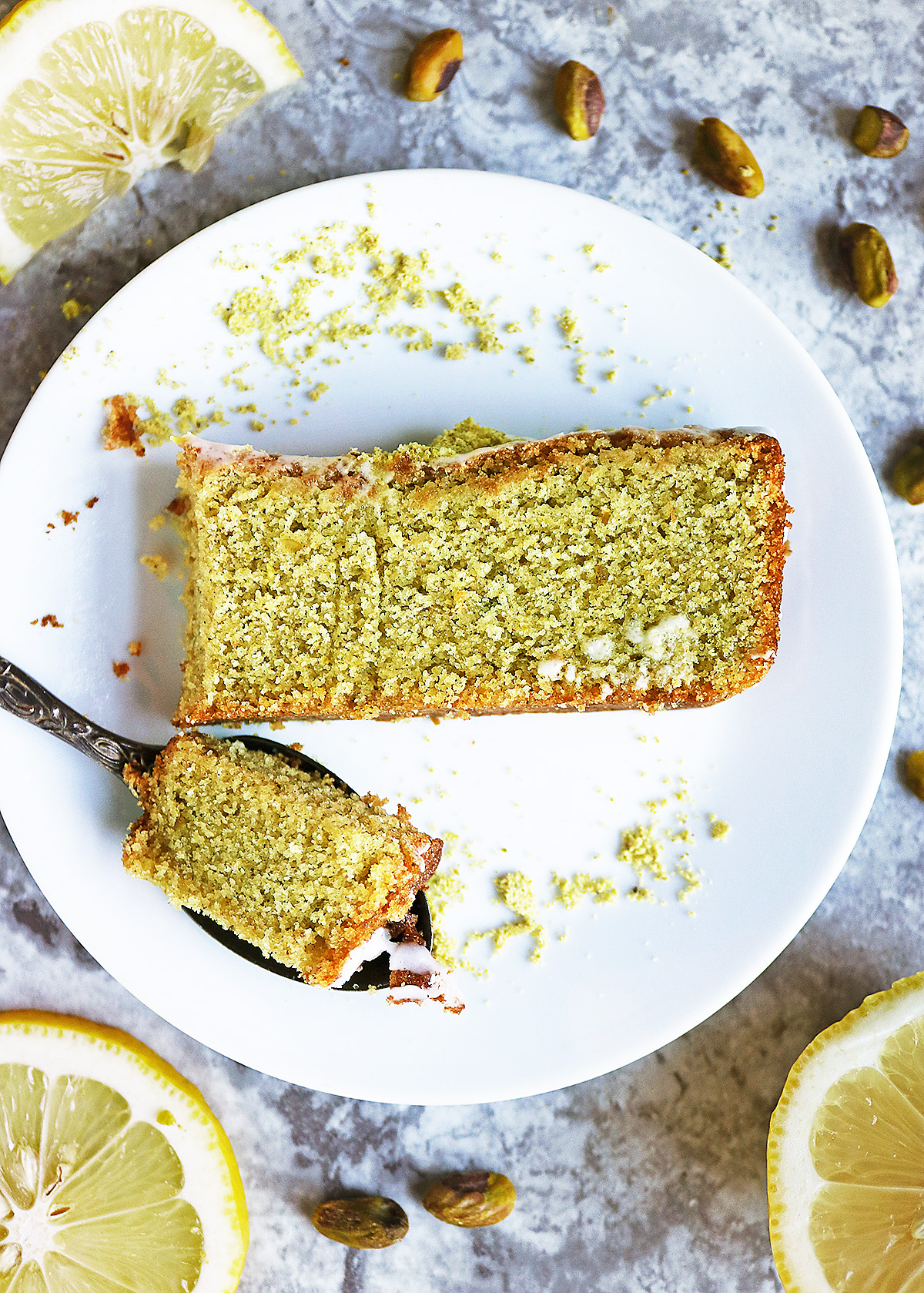 A slice of Easy Delicious Pistachio Lemon cake with lemon drizzle.