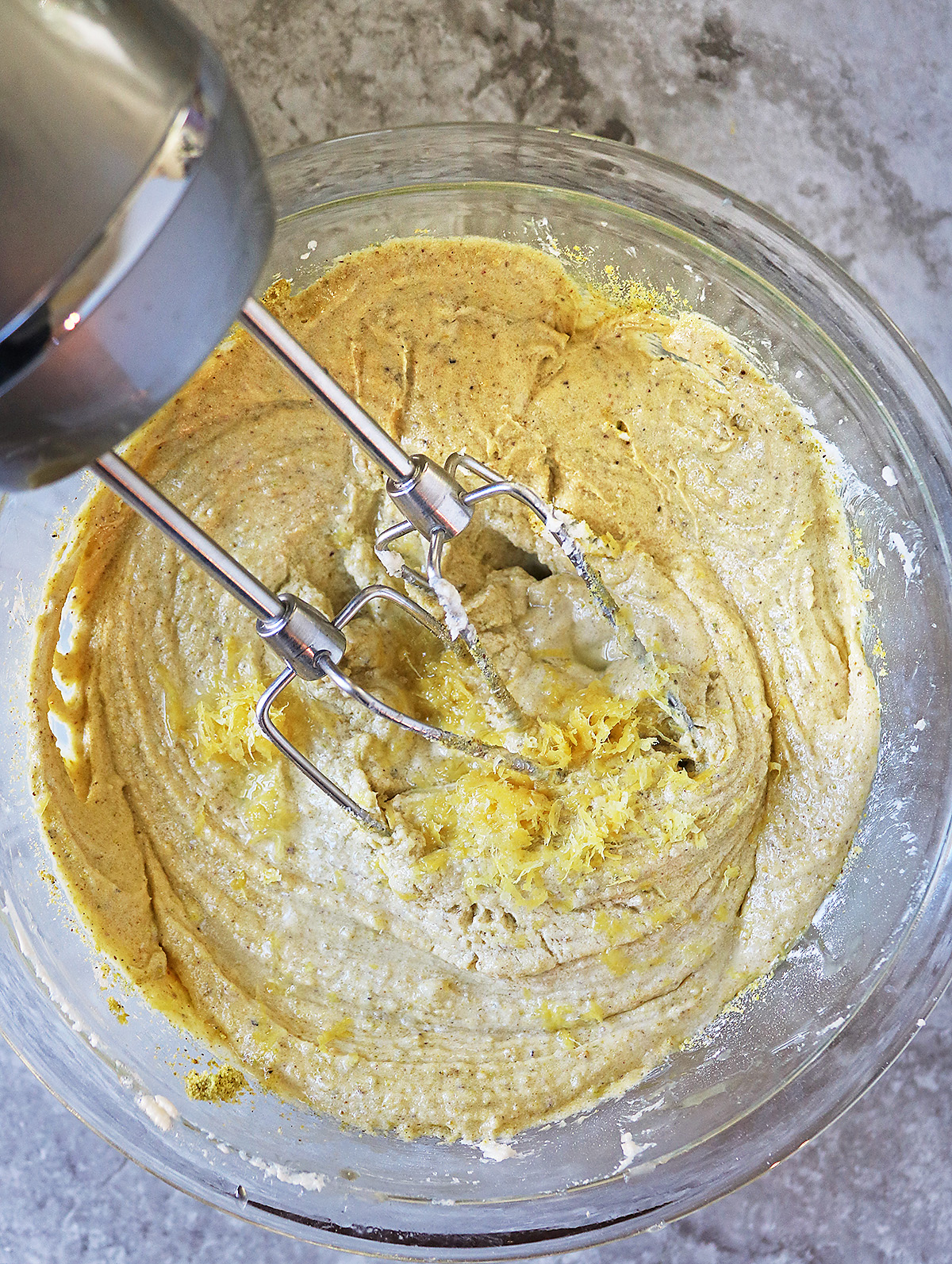 Mixing batter of lemon pistachio cake.