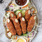 Spooky Chicken Fingers for Halloween on a silver platter with bbq sauce and honey mustard sauce.