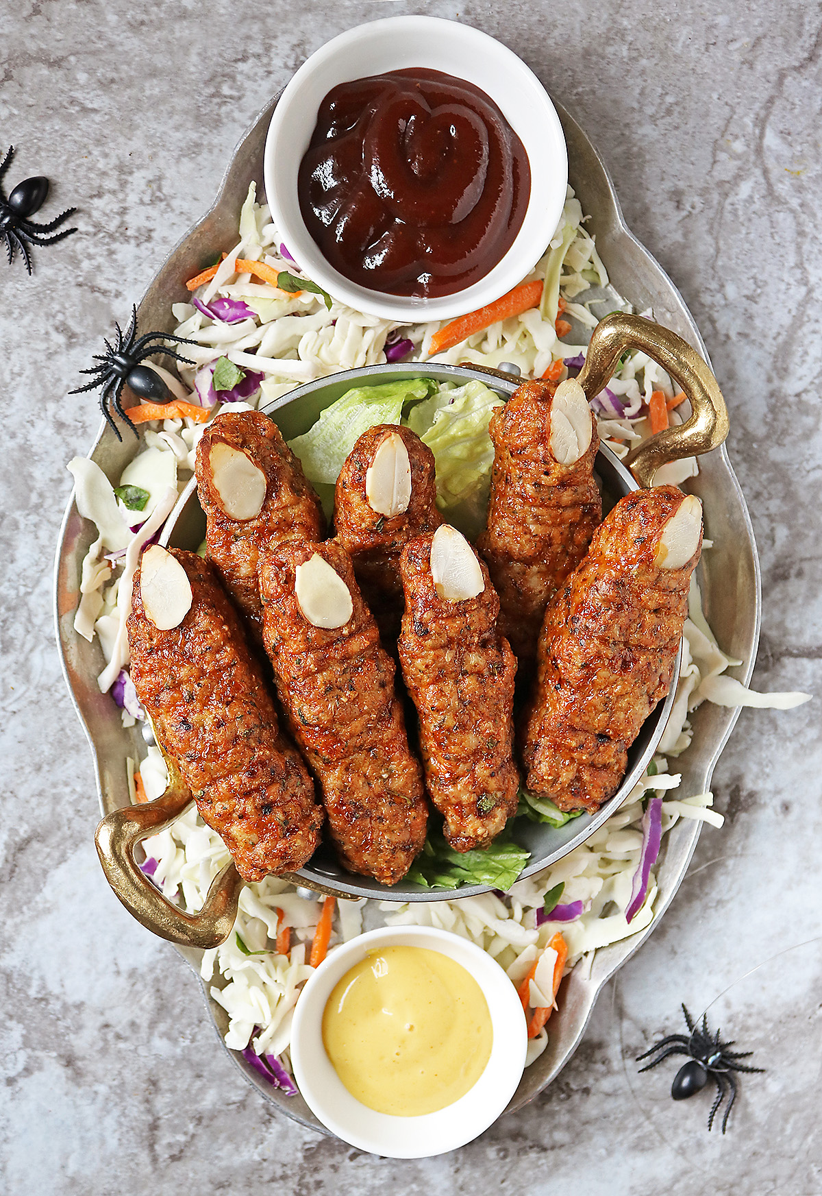 Spooky Chicken Fingers for Halloween on a silver platter with bbq sauce and honey mustard sauce.