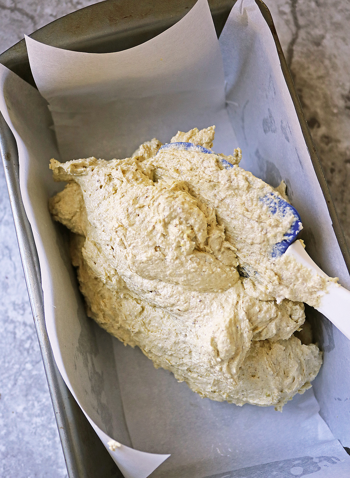 Spooning batter into loaf pan.