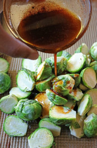 Drizzling BERBERE INFUSED oil on brussels sprouts