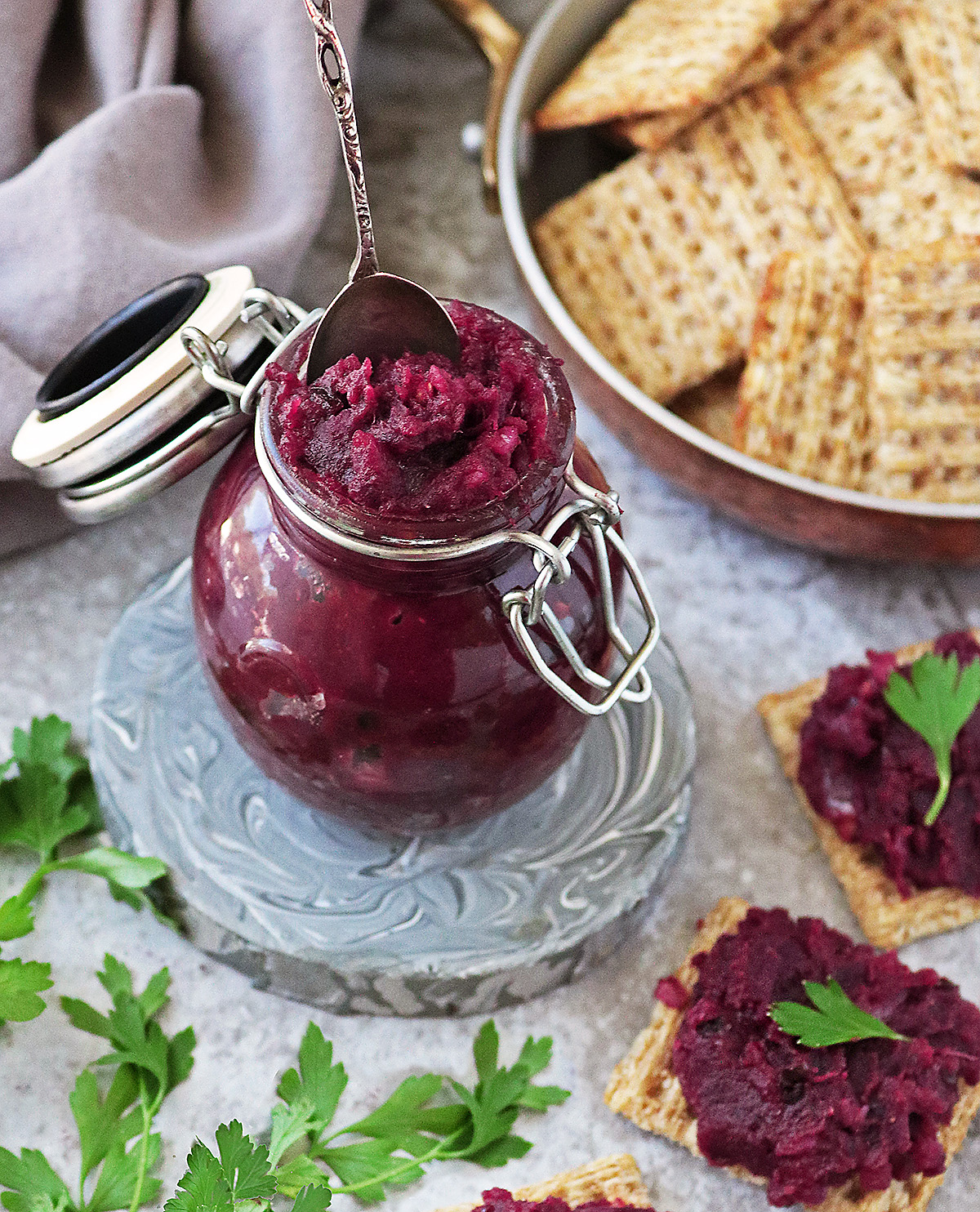 Easy purple sweet potato chutney in a small jar with crackers around.