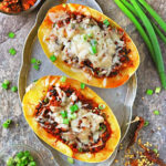 Easy Chicken Stuffed Spaghetti Squash with chicken and vegetables cooked in a delicios spiced tomato sauce, then topped with cheese and baked until cheese is bubbly.