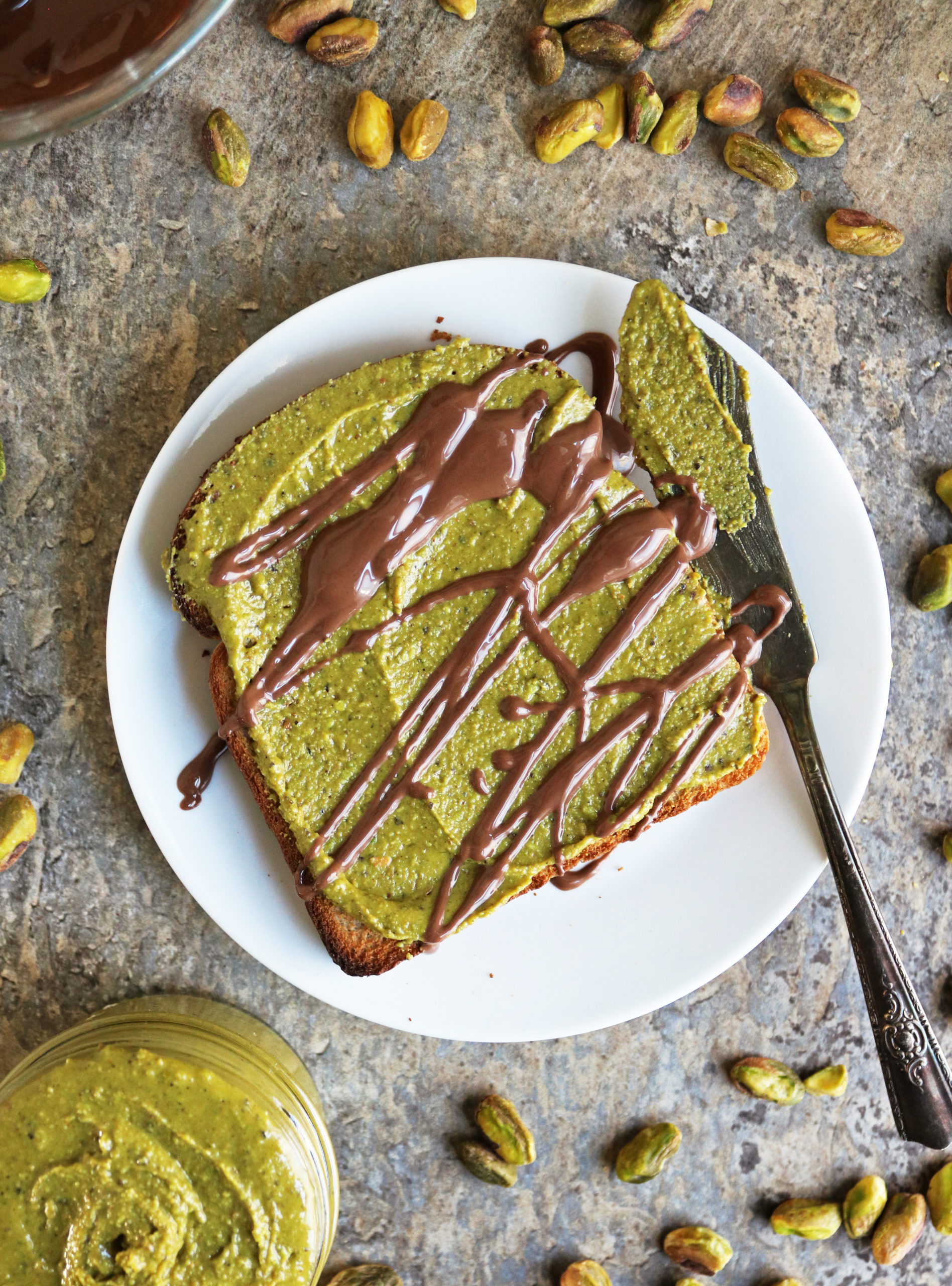 Toast slathered with pistachio butter and drizzled with melted chocolate