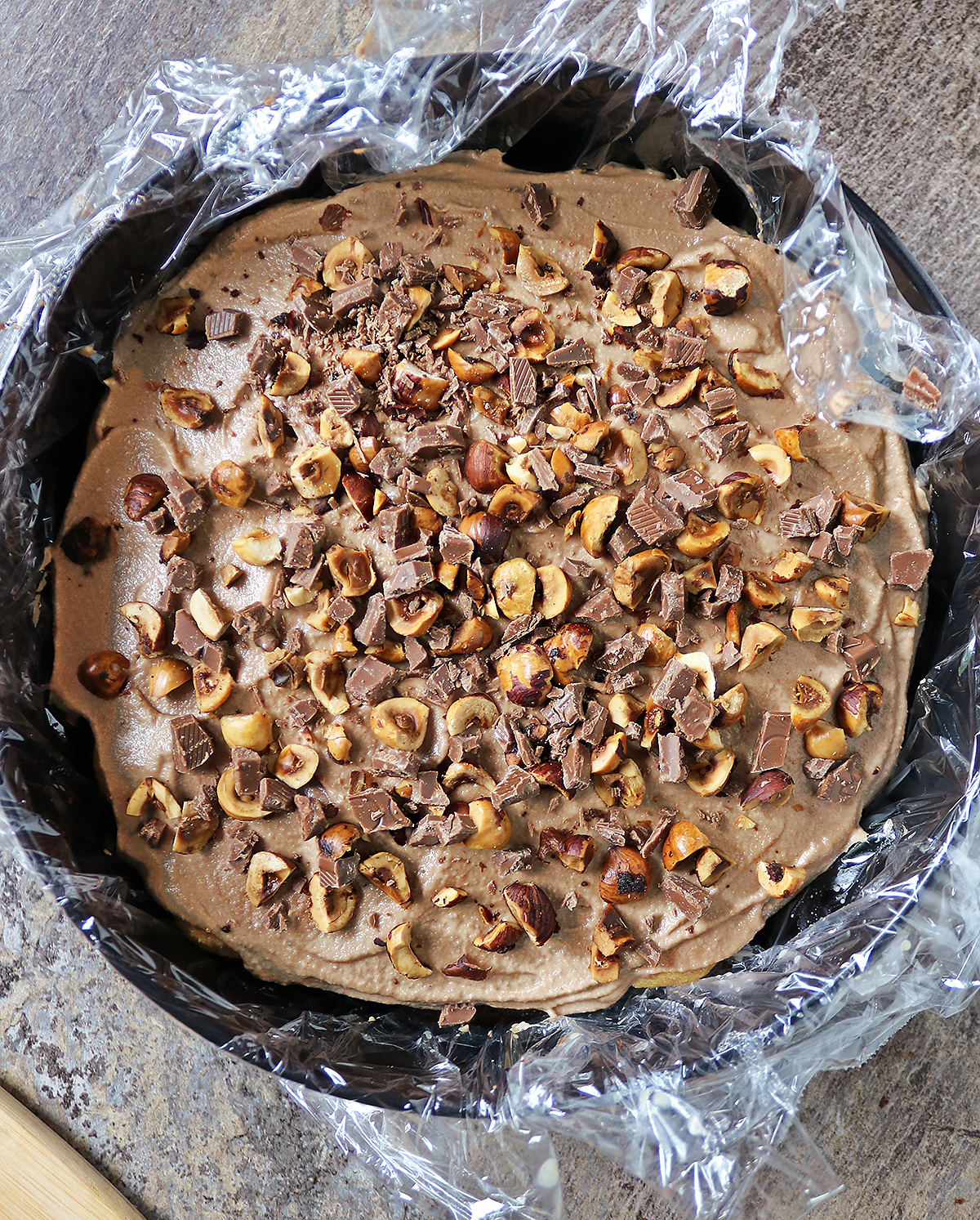 Layering chocolate bits with the hazelnuts over chocolate mousse over dulce de leche soaked ladyfingers