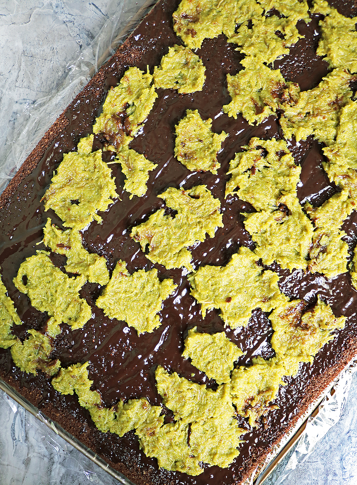 Adding a layer of Pistachio cream and katafi over chocolate ganache