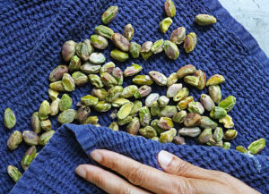 Rub warm pistachios with a towel