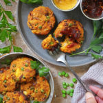 Air fried green pea patties on a plate and some in a serving dish, with parsley around.