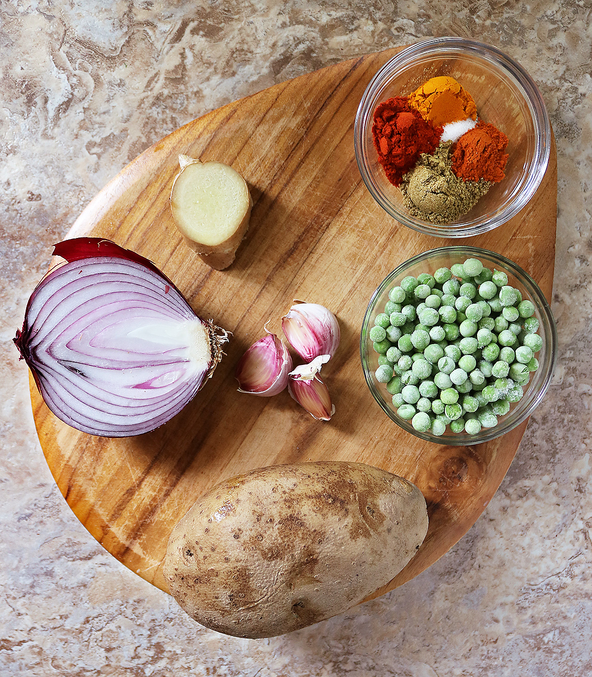 10 Ingredients to make green pea patties on a brown platter.