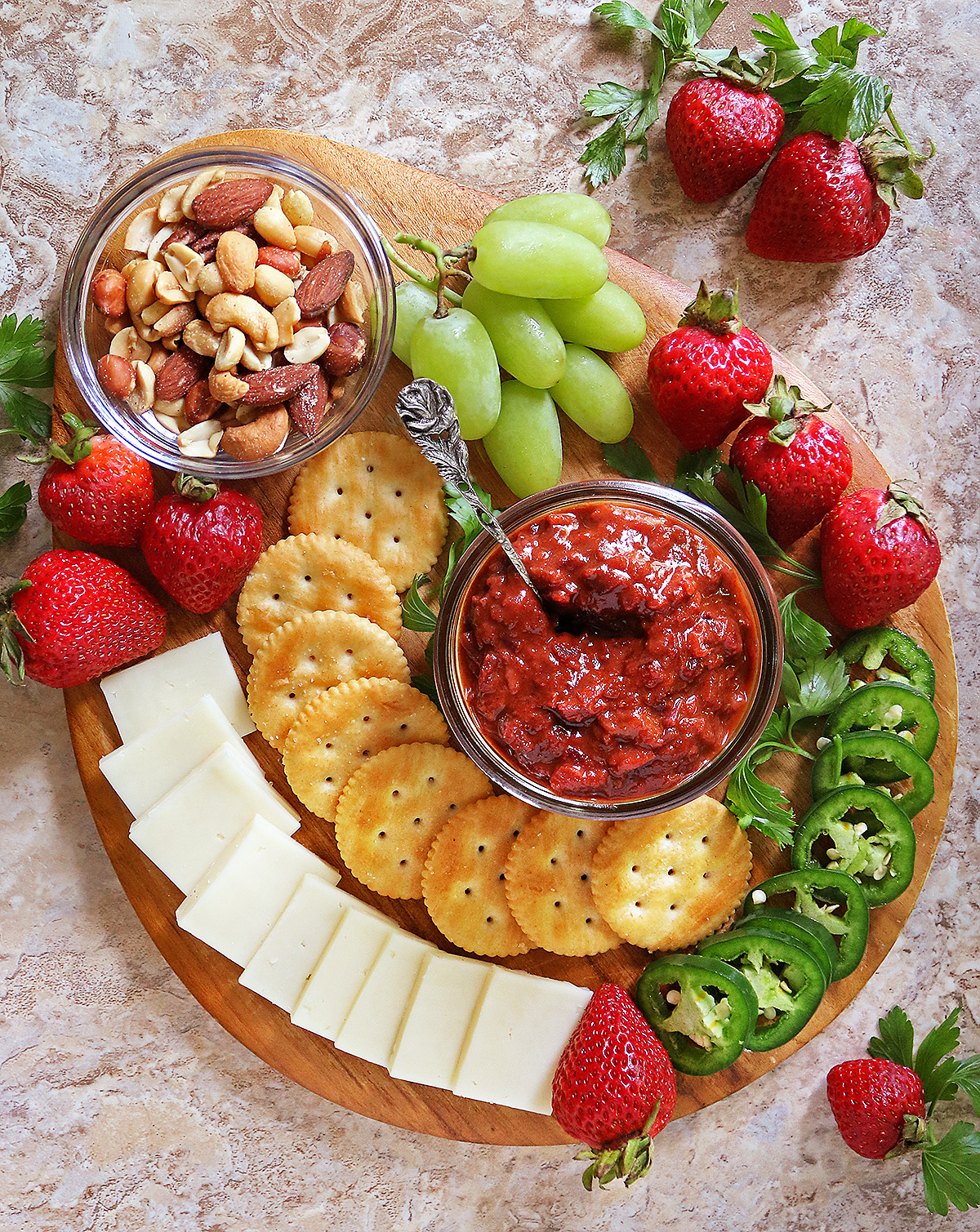 The best strawberry chutney on a charcuterie board with crackers, cheese, nuts, and fruits.
