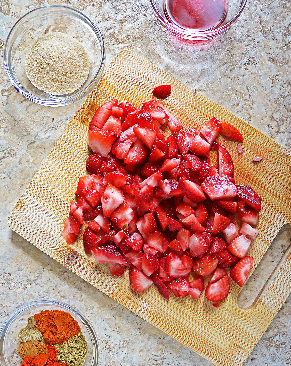 Diced strawberries on a board.