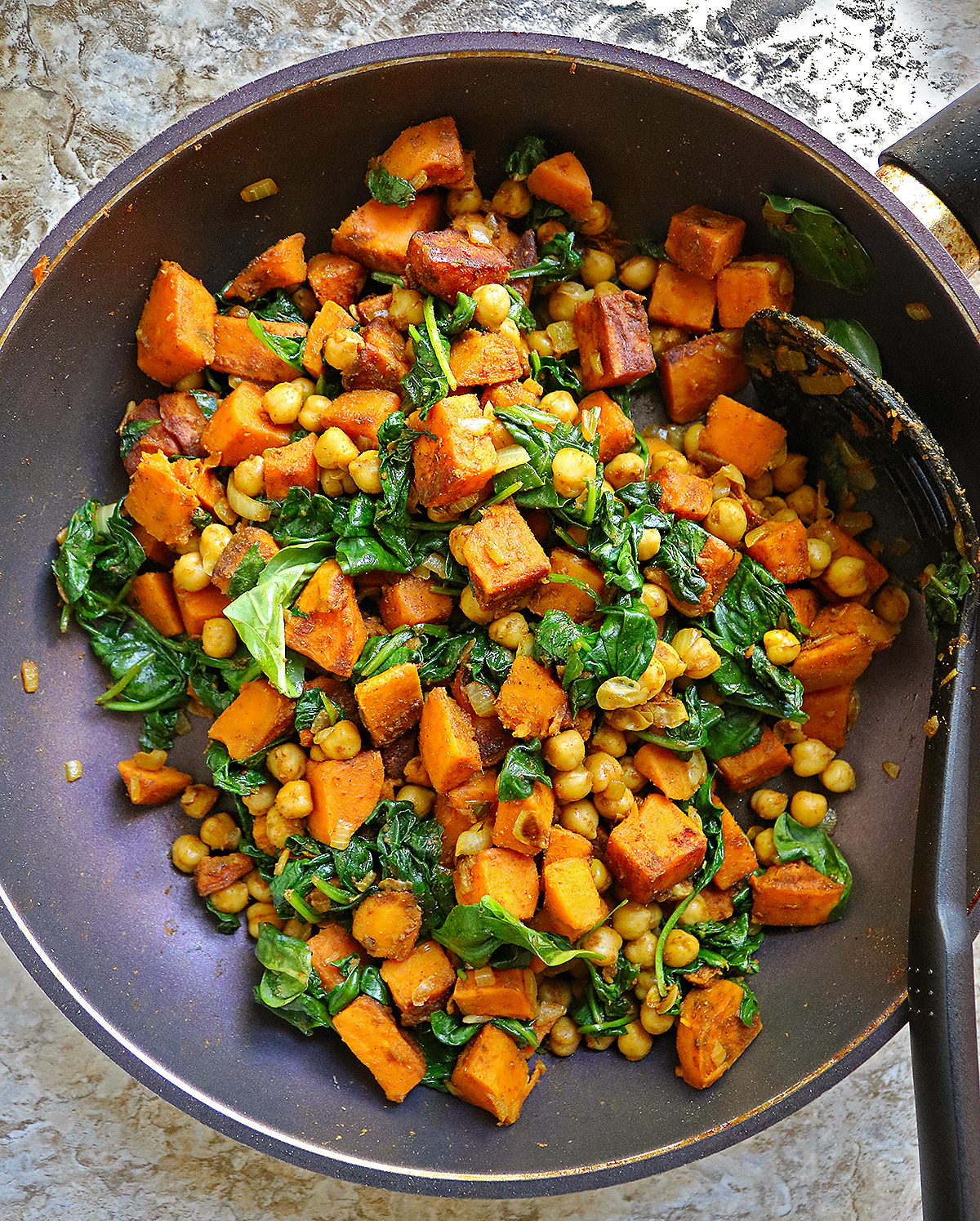 Spicy Chickpeas Sweet Potato Spinach Saute in a pan over the stovetop with the most tender sweet potatoes.